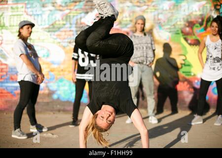 Junge Frauen in einen Breakdance Handstand Einfrieren Stockfoto
