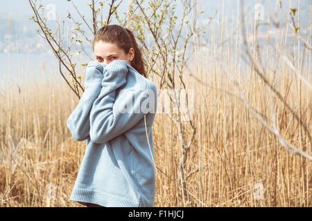Porträt der jungen Frau mit blauen Pullover am Seeufer, Mergozzo See, Verbania, Piemont, Italien Stockfoto