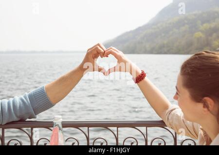 Paar macht Herzform mit Händen, Mergozzo See, Verbania, Piemont, Italien Stockfoto