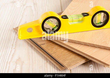 Stücke Holz Laminatboden bereit, mit einer Wasserwaage Wasserwaage verlegt werden Stockfoto