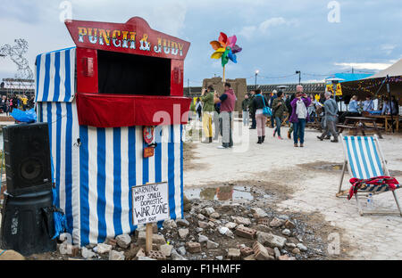 Punch and Judy show im Blick über Banksy Dismaland, Verblüffung Park direkt am Meer in Weston-super-Mare bei Sonnenuntergang. Stockfoto