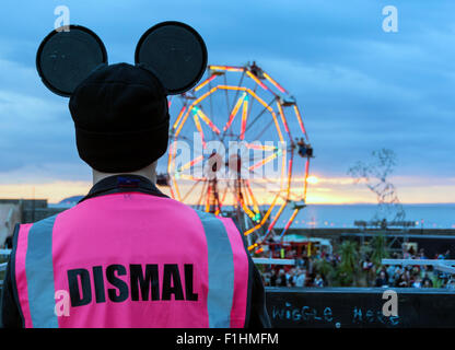 Mitarbeiter bei Blick über Banksy Dismaland, Verblüffung Park direkt am Meer in Weston-super-Mare bei Sonnenuntergang. Stockfoto