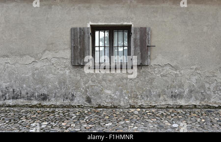 Verwitterte rissige Wand mit alten Holzfenster. Stein Texturen Hintergrund Stockfoto