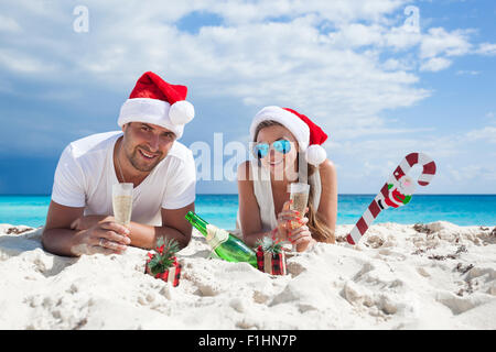 Glückliches Paar feiert Weihnachten am Strand Stockfoto