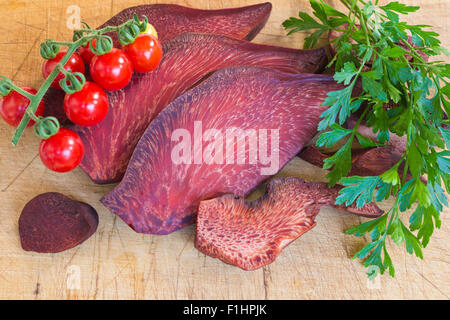 Abschnitt von Fistulina Hepatica (Beefsteak Pilz) und Cherry-Tomaten und Blätter der Petersilie auf hölzernen Hintergrund Stockfoto