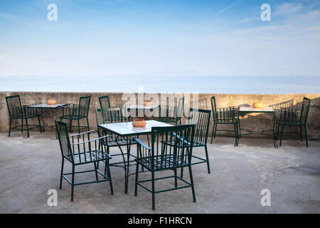 Freifläche am Meer Interieur mit Metallstühlen unter blauem Himmel Stockfoto