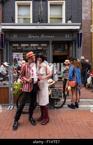 Ein paar in der Mode der 1920er Jahre vor Davy Byrnes Pub auf Duke Street feiert Bloomsday, Dublin, Irland. Stockfoto