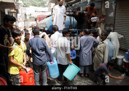 Menschen füllen ihre Trinkwasser kann am Wasser Tanker aufgrund des Mangels an Trinkwasser in ihrem Gebiet am Baghbanpura in Lahore am Mittwoch, 2. September 2015. Stockfoto