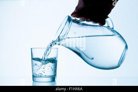 Wasser aus einem Krug in ein Glas gegossen Stockfoto