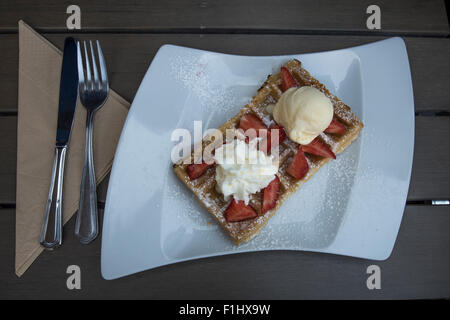Leckere süße Waffel mit Sahne, Eis und Erdbeeren in eine Waffel-Shop in Brügge, Belgien. Einen perfekten Einstieg in die d Stockfoto