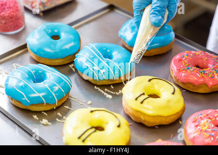 sortierte glasierte Donuts in verschiedenen Farben auf Hintergrund Stockfoto