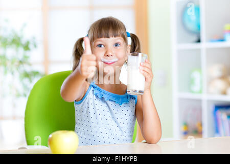 Kind trinkt Milch und Daumen auftauchen Stockfoto