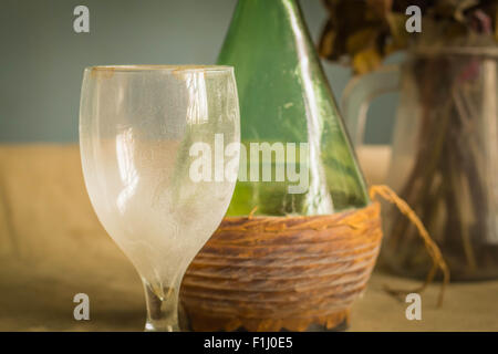 Glas und Wein Flasche mit Staub auf dem Tisch. Stockfoto