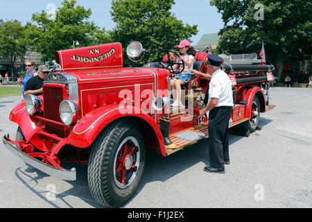 Alten Feuerwehrmann zeigen Kinder einer antiken Feuerwehrauto Greenport Long Island New York Stockfoto