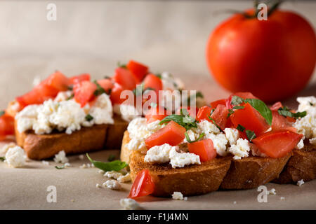 Italienische Vorspeise Bruschetta mit gerösteten Tomaten, Käse und Kräutern Stockfoto