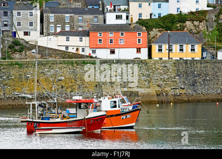 Mevagissey in Cornwall, England und eine Sammlung von Fischerboote im kleinen Hafen an einem Sommermorgen vertäut. Stockfoto