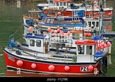 Mevagissey in Cornwall, England und eine Sammlung von Fischerboote im kleinen Hafen an einem Sommermorgen vertäut. Stockfoto