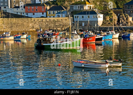 Mevagissey in Cornwall, England und eine Sammlung von Fischerboote im kleinen Hafen an einem Sommermorgen vertäut. Stockfoto