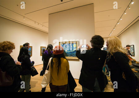 Viele Menschen versammelt, um die Vincent Van Gogh Gemälde The Starry Night in The Museum of Modern Art in New York City Stockfoto