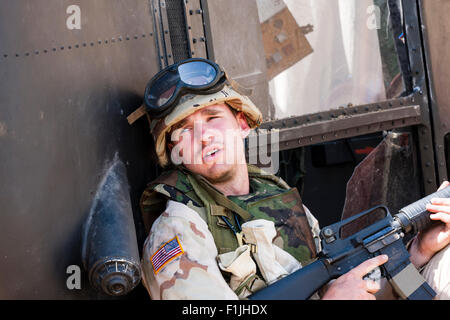 Amerikanische Armee, Black Hawk Re-enactment. Müde suchen Soldat Deckung von abgestürzten Hubschrauber, Holding M 16 rife bereit. In Mogadischu. Stockfoto