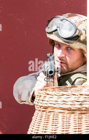 Amerikanische Armee, Black Hawk Reenactment, Krieg und Frieden zeigen. Soldat mit Helm, Schutzbrille auf Ziel in Viewer von hinter dem Korb. Stockfoto