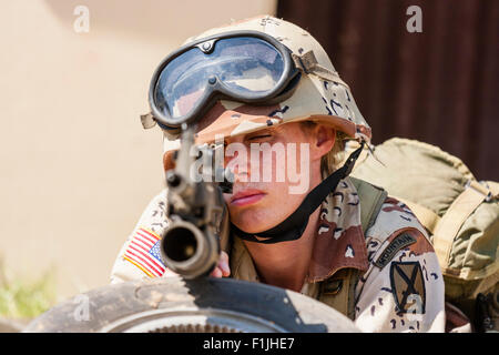 Amerikanische Armee, Black Hawk Re-enactment, Krieg und Frieden zeigen. Frau Soldat zur Festlegung, die Pistole direkt auf Viewer. Fokus auf Gesicht der Frau. Stockfoto