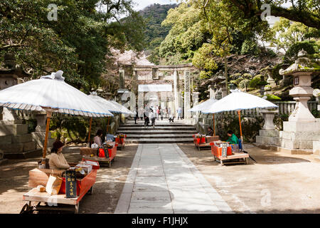 Eingang zum Kotohira-gu Tempel, oft als Kompira-san. Pfad zwischen den Marktständen im Schatten von großen Sonnenschirmen mit Stufen Tor torii. Stockfoto