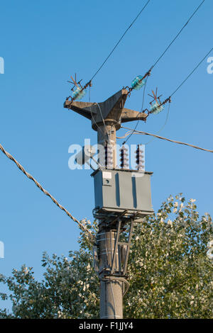 Elektrischen Transformator auf einem Zement Beton macht Pol blauen Himmel im Hintergrund Stockfoto