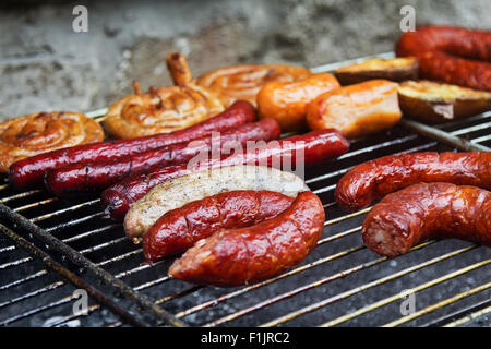 Auswahl an gegrillten Würstchen und Wurst auf großen Grill. Selektiven Fokus auf die Weißwurst. Stockfoto