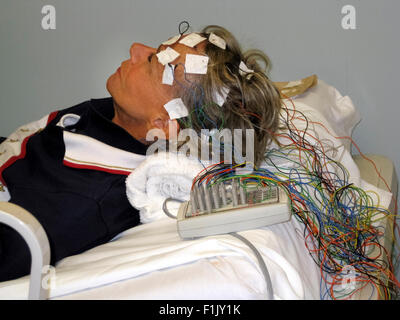 Eine Frau in einer Arztpraxis wird unterzogen Elektroenzephalogramm (EEG) zur Erkennung von Anomalien in die elektrische Aktivität ihres Gehirns. Stockfoto