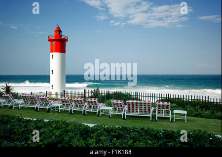 Liegestühle mit Blick auf den Strand und Leuchtturm von Umhlanga Rocks, Kwa-Zulu Natal. Stockfoto