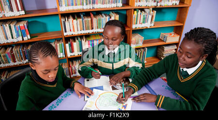 Drei Mädchen arbeiten zusammen an einem Schreibtisch, Meyerton Primary School, Meyerton, Gauteng Stockfoto