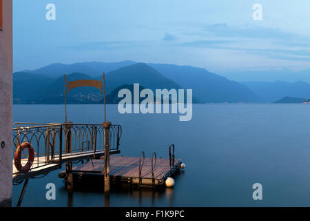 Blick Richtung Bellagio auf den Comer See von Varenna, Italien, am Abend mit Steg im Vordergrund. Stockfoto