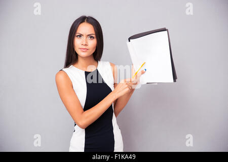 Porträt einer jungen Frau mit Vertrag über grauen Hintergrund Stockfoto