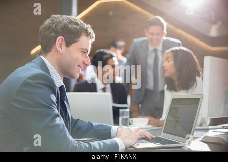 Lächelnd Geschäftsmann arbeiten am Laptop im Büro Stockfoto