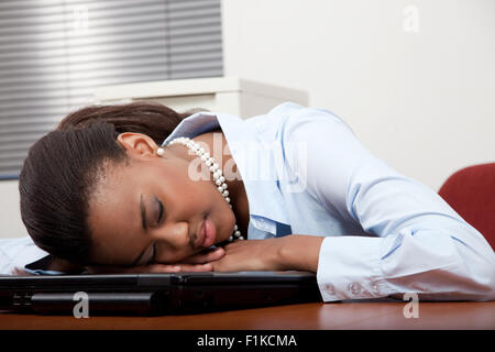 Eine schwarze Geschäftsfrau schlafend an ihrem Schreibtisch Stockfoto