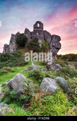 Dramatische feurigen Sonnenuntergang über Roche Rock, eine schroffe Felsen aus Granit mit der alten Ruine einer Kapelle, erbaut auf den Felsen in der Nähe von Stockfoto