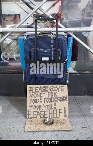 Hungrige Obdachlose Person richtet ein Bürgersteig Anzeige wo Passanten Geld spenden können. Stockfoto