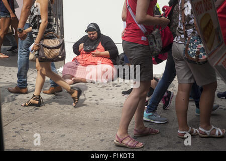 Blinde Frau sitzt an der 34th St. betteln um Geld & helfen in Midtown Manhattan, NYC. Stockfoto