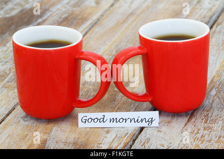 Guten Morgen Karte mit zwei roten Becher Kaffee auf rustikale Oberfläche Stockfoto