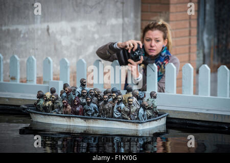 Straße des Künstlers Banksy Dismaland in Weston-Super-Mare. Abgebildete Stück ausgestattet mit ferngesteuerten Boote mit Migranten verpackt. Stockfoto