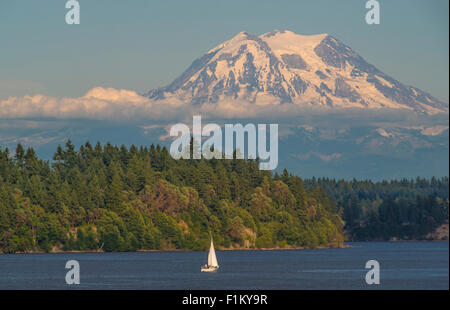 Nahaufnahme des Mount Rainier und Menschen im Segelboot segeln. Puget Sound, Squaxin Island, US-Bundesstaat Washington. USA Stockfoto