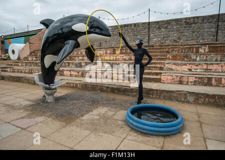 Ein Modell-Killer-Wal springt aus einer Toilette im Rahmen von Banksy Dismaland Verblüffung Park Pop-up-Ausstellung in Weston-Super-Mare. Stockfoto