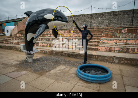 Ein Modell-Killer-Wal springt aus einer Toilette im Rahmen von Banksy Dismaland Verblüffung Park Pop-up-Ausstellung in Weston-Super-Mare. Stockfoto