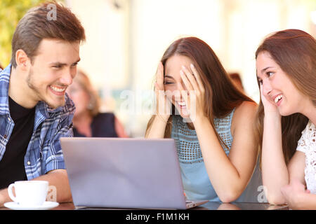 Glückliche Freunde Laptop schenken einem überrascht Mädchen in einem Coffee-shop Stockfoto