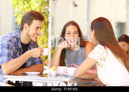 Drei glückliche Freunde reden und Lachen in einer Café-Terrasse Stockfoto