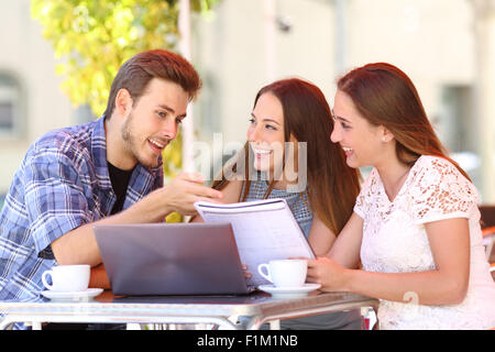 Drei Studenten studieren und lernen in einem Café mit einem Laptop und Notizen Stockfoto