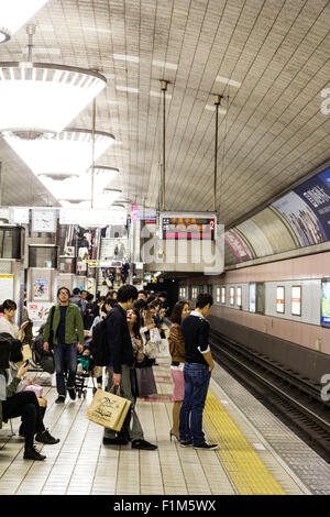 Osaka Shinsaibashi U-Bahn, U-Bahn Station. Die Passagiere stehen auf der Plattform beim Warten auf den nächsten Zug zu gelangen. Stockfoto