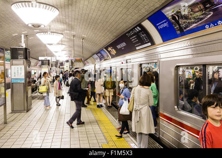 Osaka Shinsaibashi U-Bahn, U-Bahn Station. Entlang Plattform, Pendler, die beim Ein- und Aussteigen. Besetzt. Stockfoto