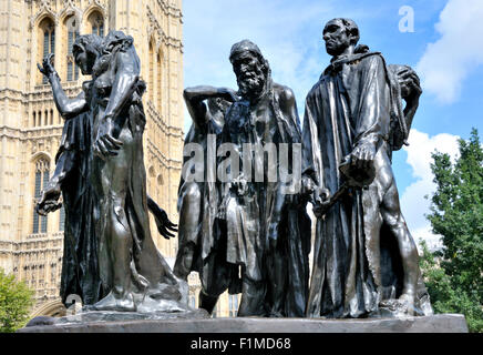 London, England, Vereinigtes Königreich. Rodins Bürger von Calais (1895) in der Victoria Tower Gardens, Westminster. Häuser des Parlaments hinter. Stockfoto